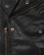 Close-up of the asymmetrical zipper on a men's black motorcycle leather jacket.