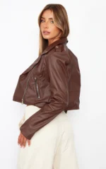 Back view of a chocolate faux leather biker jacket with zippered pockets.