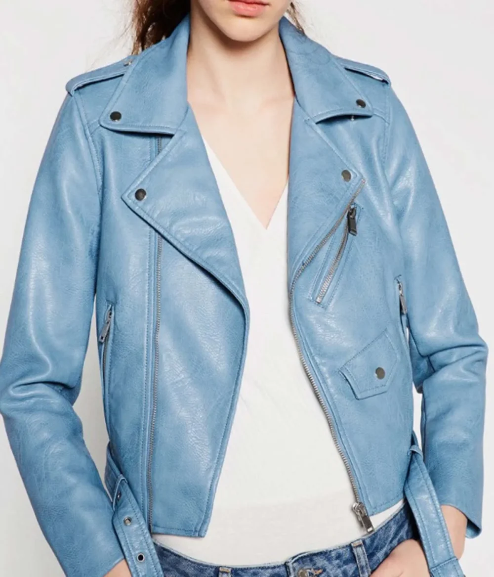 A woman wearing a baby blue motorcycle leather jacket, paired with jeans and a T-shirt.