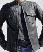 Model wearing a black cafe racer leather jacket with the front closure open, showcasing the interior lining and details.