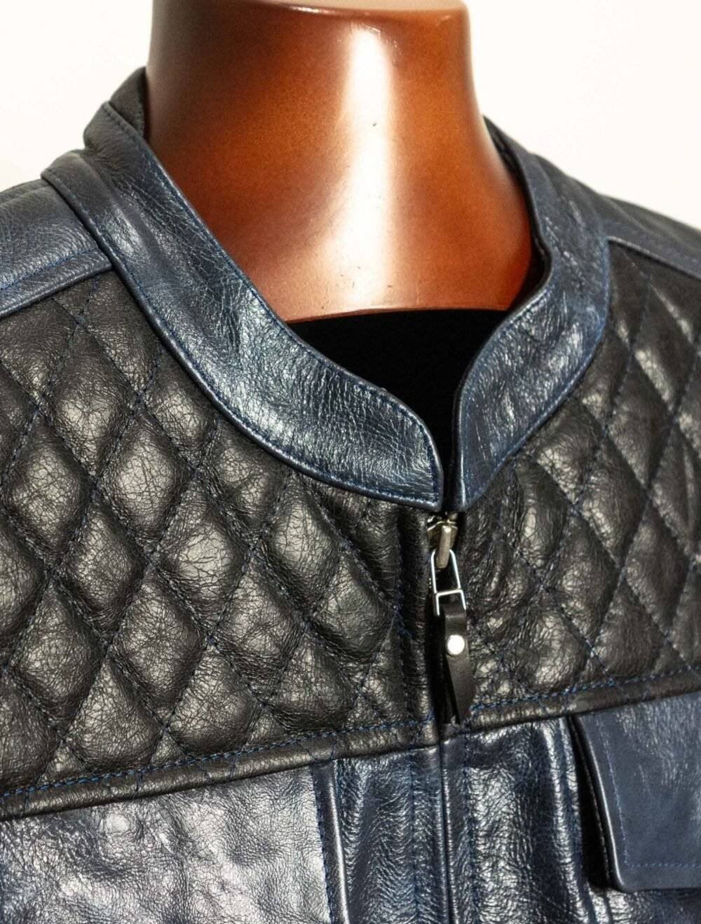 Close-up of the diamond-stitched detailing and color combination on the front of the blue black leather motorcycle vest.