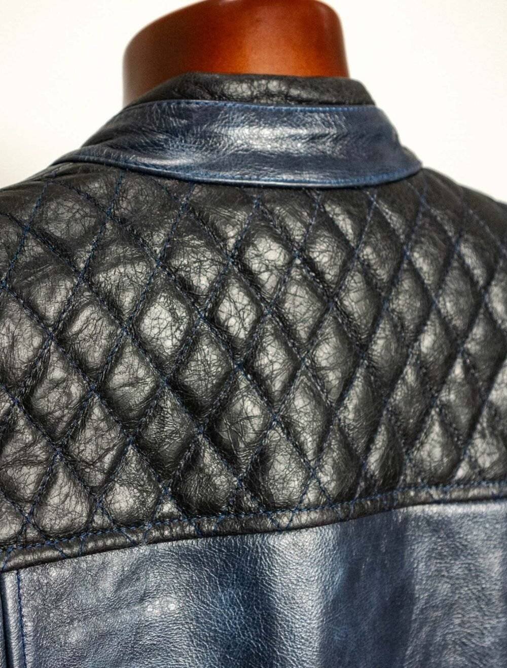 Close-up of the diamond-stitched detailing and full interior leather facings on the back of the blue black leather motorcycle vest.