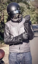 Model wearing a handcrafted men's slim fit leather jacket with a motorcycle helmet.