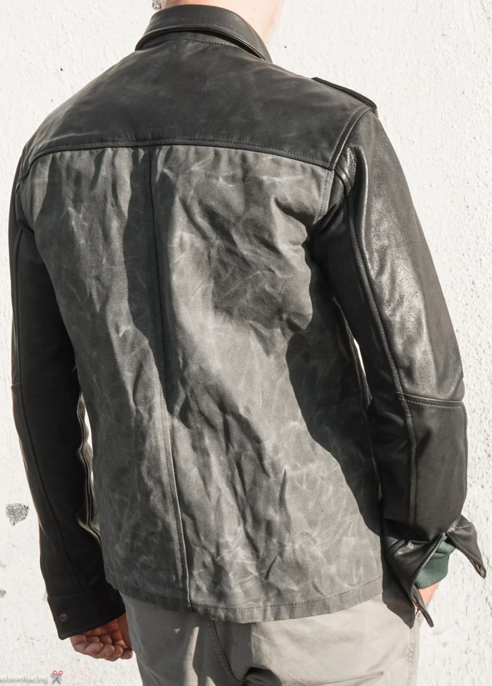 Back view of a men's black shirt jacket with a button-up closure and two front pockets.