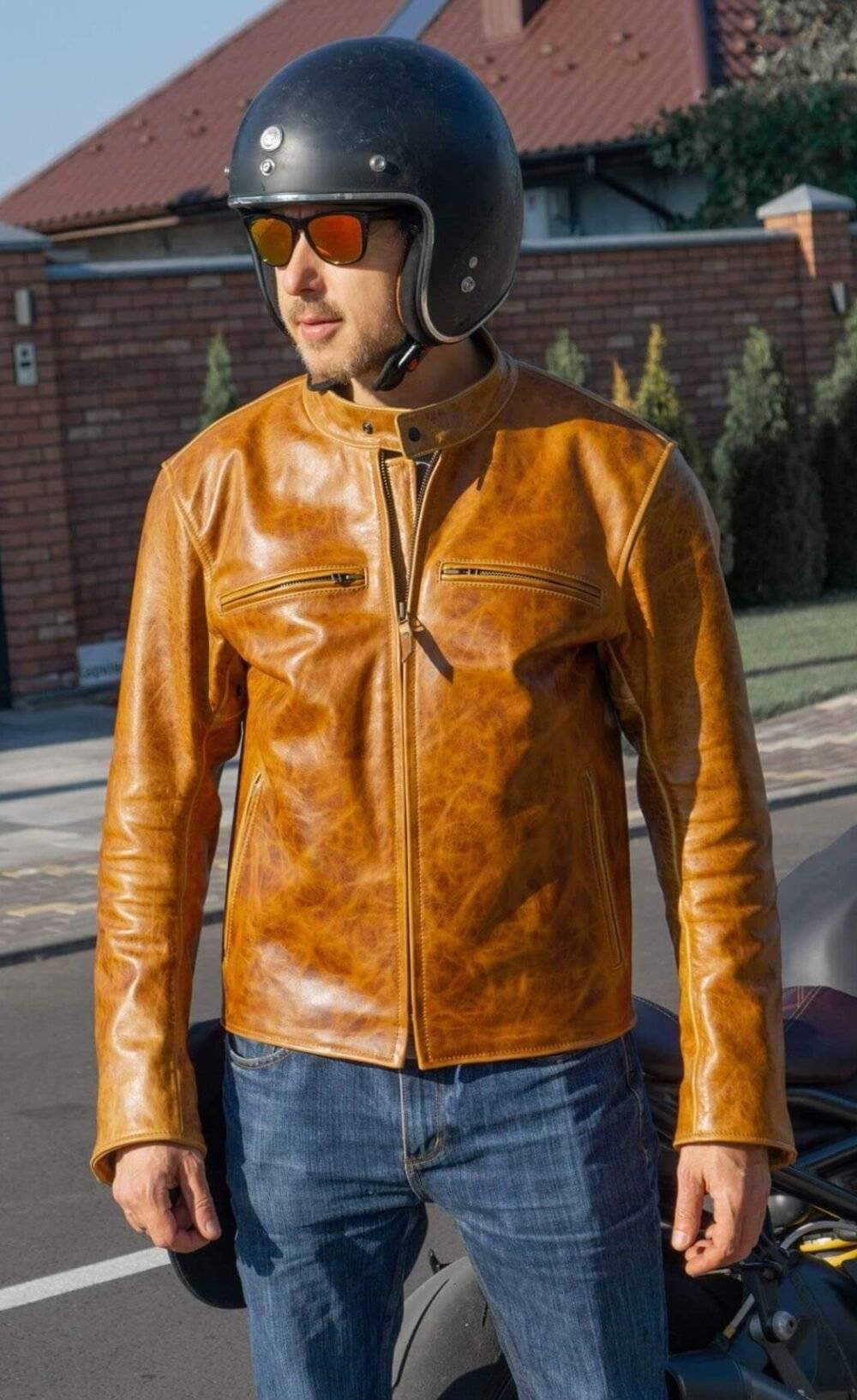 Orange and brown leather racing jacket with armor protection and a classic biker silhouette.