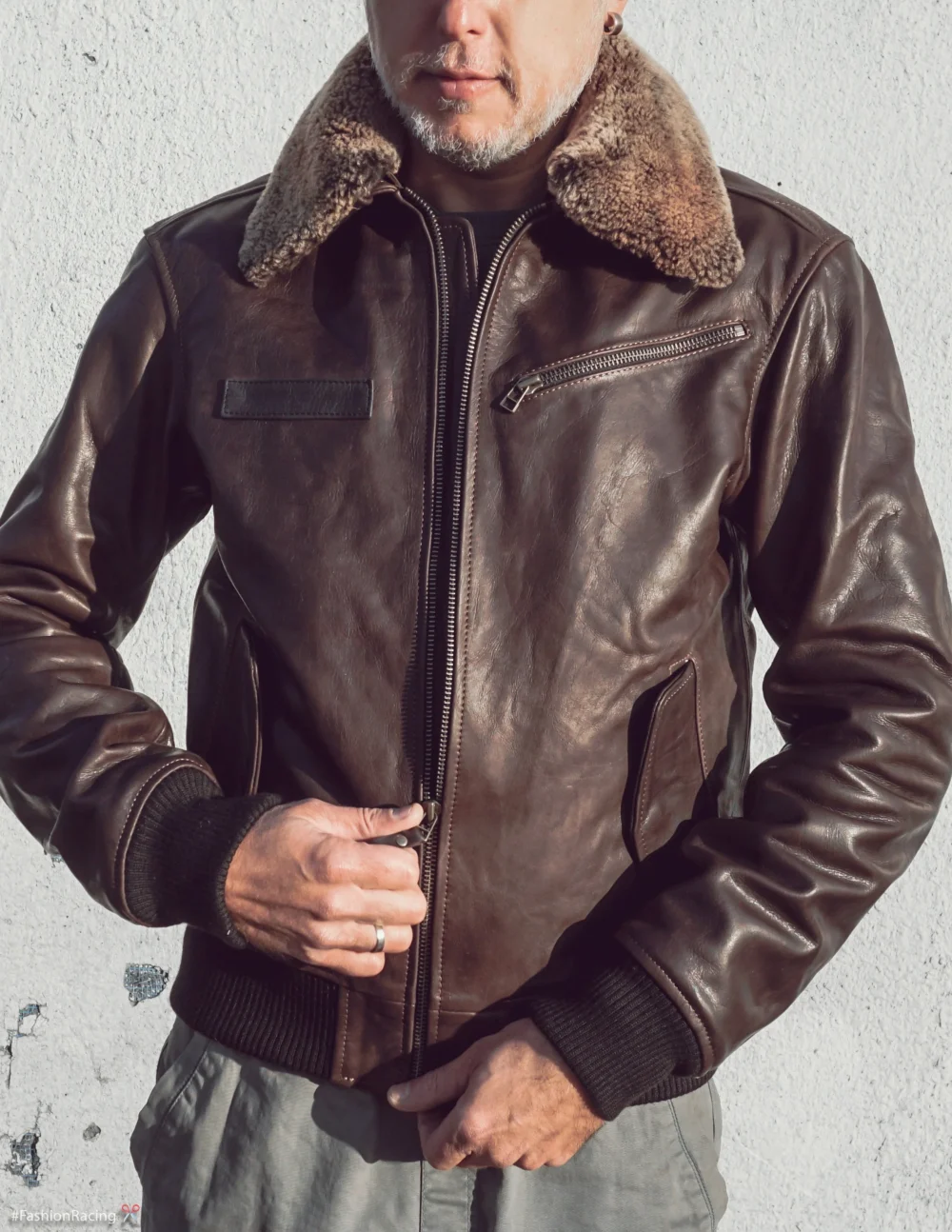 Men's brown vintage aviator leather jacket with detachable natural fur collar and snap closure, closed.